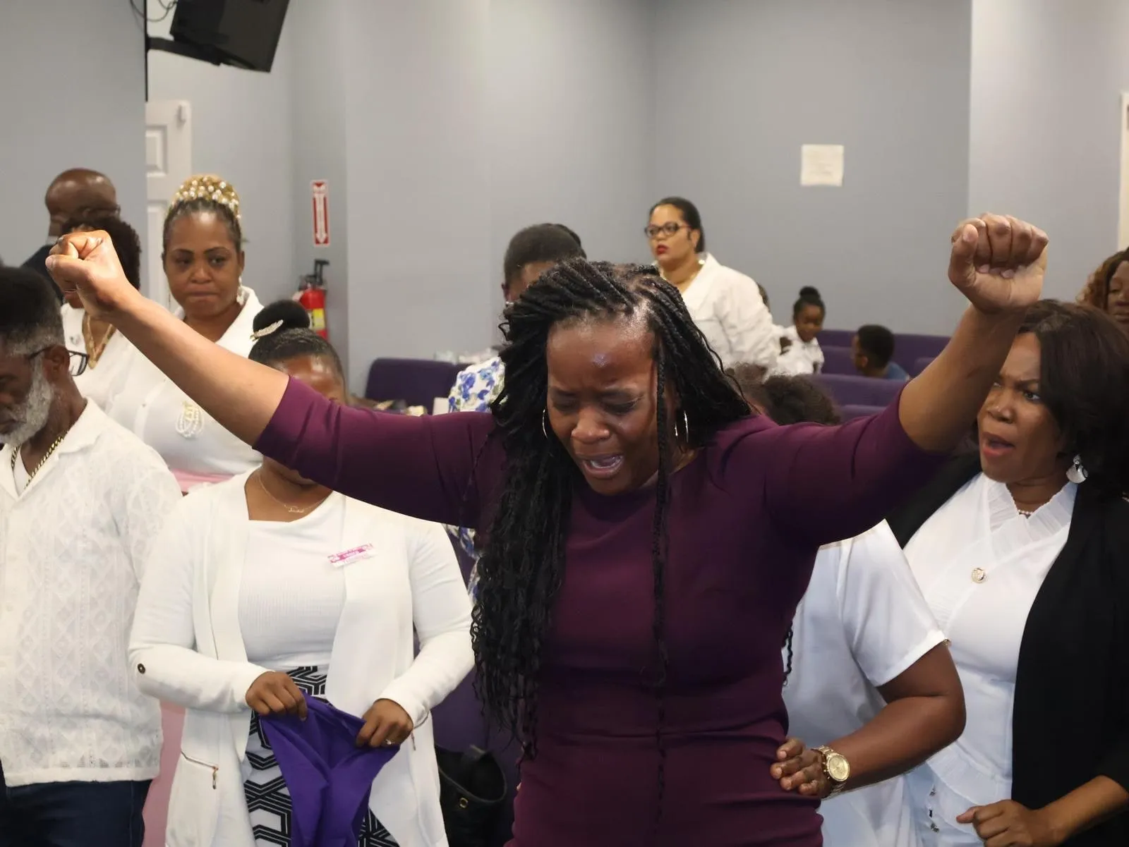 A member of the congregation worshipping with hands raised